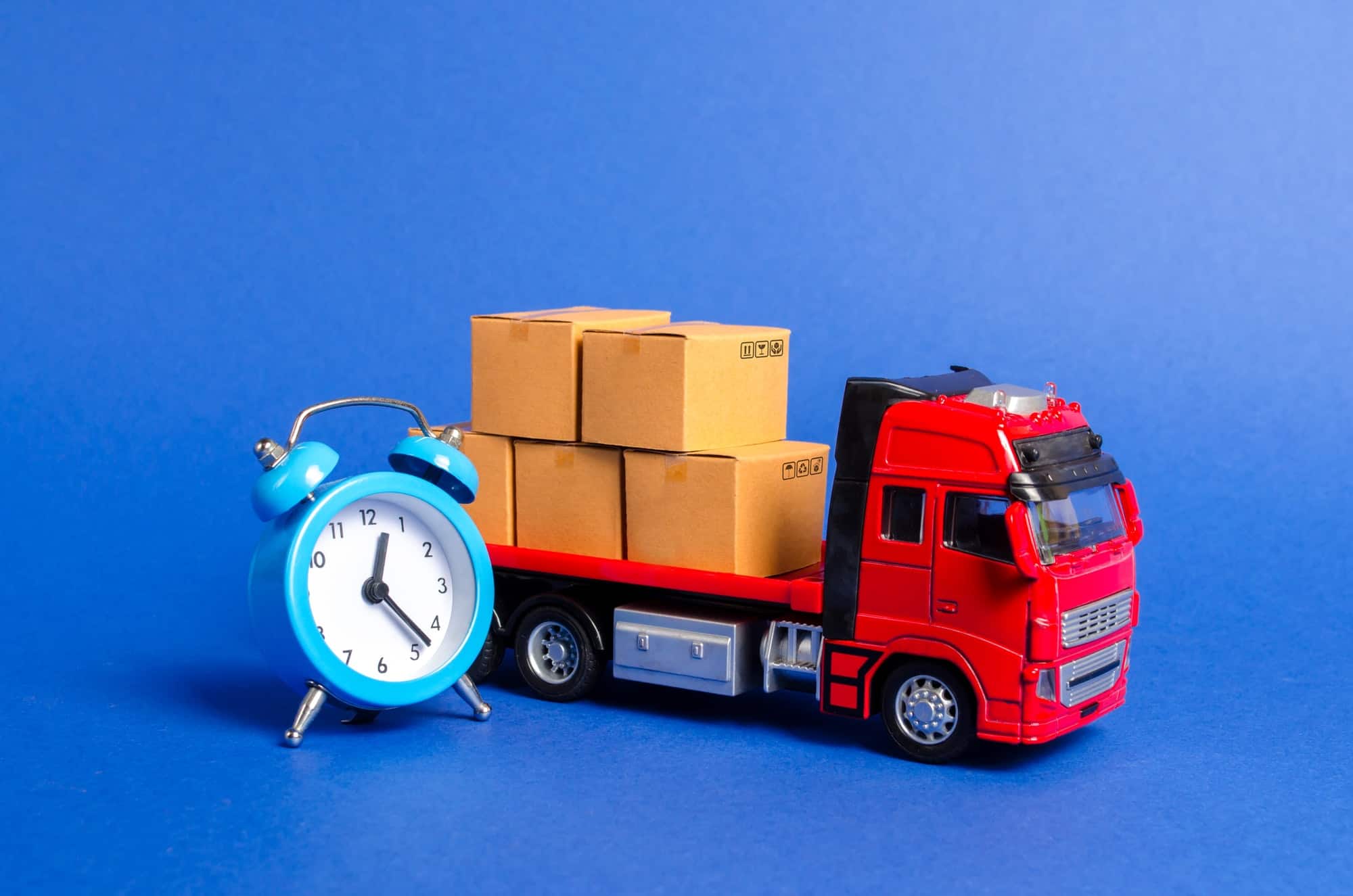 A red truck with cardboard boxes and a blue alarm clock